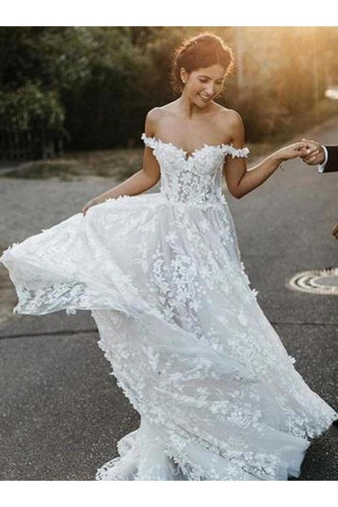 Vestido de novia estilo boho con hombros descubiertos y apliques de una línea